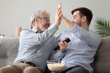 Happy father and son celebrate team win at home