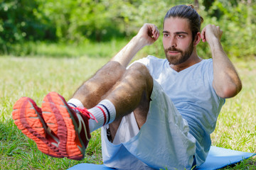young sportsman doing abdominal crunches outdoors