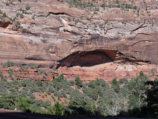Small cave in the immese rocky walls of red cliffs at Zion National Park, Utah.