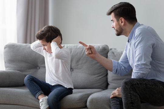 Angry dad scolding preschooler son having dispute at home
