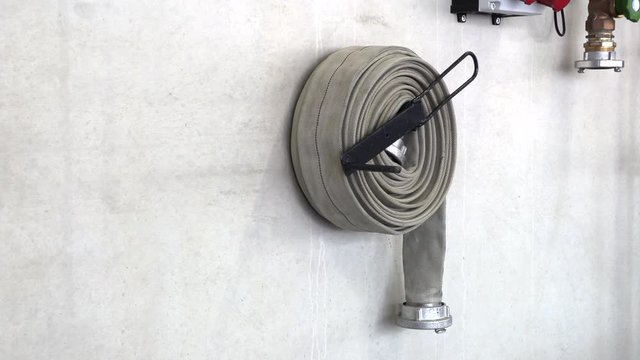 Fire hose reeled up hanging on the wall