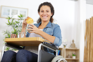 young woman in wheelchair drinking coffee indoors