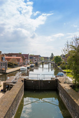 Naklejka premium A canal with lock in a historical city in the lake side district of the Netherlands.