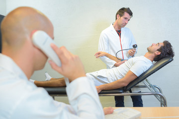 doctor on the phone while patient lying on bed