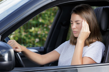 Fototapeta na wymiar young female driver with headache in a car