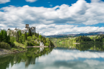 Fototapeta na wymiar Niedzica castle on hill top, lond exposure motion blur at lake Czorsztyn and clouds on sky