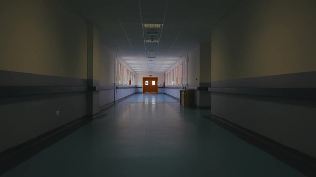 Long empty corridor of a large building, towards the exit. Passage through a long empty corridor to exit direction. First person view