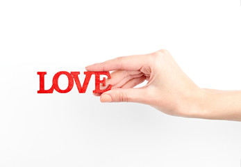 Female hand isolated on white background. White woman's hand showing symbols and gestures. Wooden red inscription love. Love