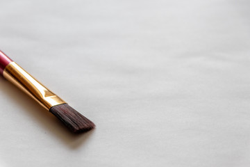 Sauberer Pinsel mit Goldfassung wartet auf den Künstler und hilft ihm bei seinem Gemälde