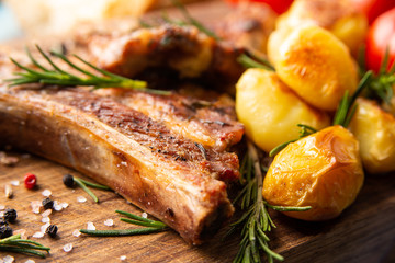 Braciole di maiale cotte alla griglia con contorno di patate arrosto e rosmarino