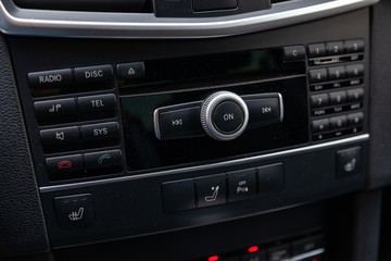 Obraz premium Control buttons for multimedia system, phone connected via bluetooth for talking on the speakerphone in the car on the black panel, heated seats and parking sensors.