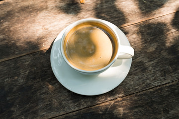 black coffee in white cup on wooden table.