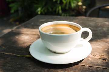 black coffee in white cup on wooden table.