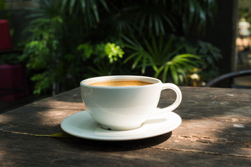 black coffee in white cup on wooden table.