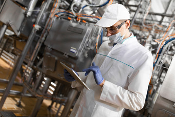man in a white robe and a cap make an inspection of the production line
