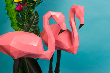 Pink flamingo tropical leaves decor in the studio on a blue background. Summer abstract art