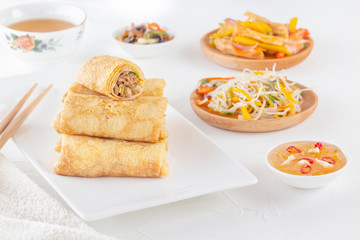 Traditional Chinese tortillas filled - bings in a plate on a white background, salads, Dam Sam snacks and cup of tea.
