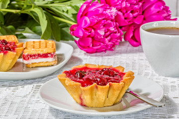 Still-life with a cup, cakes, a bouquet of peonies, macro