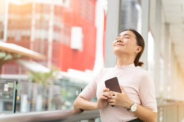 Happy woman using smart phone in the city