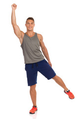 Young Fit Man Is Standing On One Leg With Arm Raised