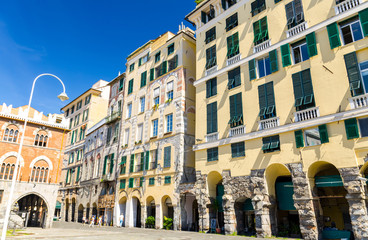 Fototapeta premium Buildings with arches, archways, portico and shutters on windows on Piazza Della Raibetta square in historical centre of old european city Genoa Genova, Liguria, Italy
