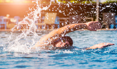 Young athletic man swimming in the swimming pool