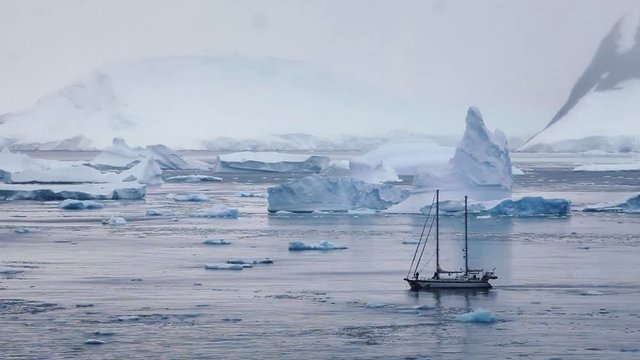 sailing boat in Antarctica, travel by yacht cruise, beautiful landscape with icebergs and mountains