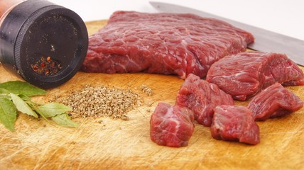 Fresh raw beef meat on cutting board with herbs and spices