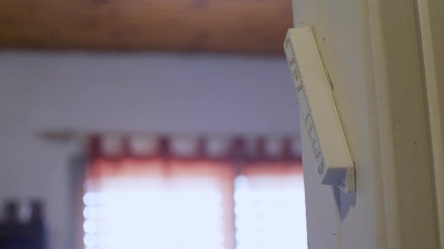 Hand touching a mezuzah on the door of a room