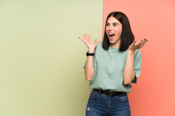 Young woman over isolated colorful wall with surprise facial expression