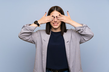 Young woman over isolated blue wall covering eyes by hands. Do not want to see something