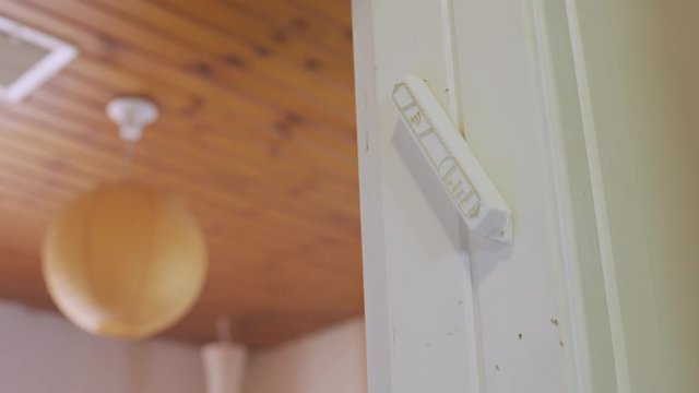 Jewish man kisses a mezuzah on the door before going into room