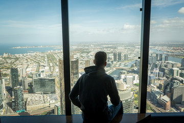 Boy on window with Melbourne skyline