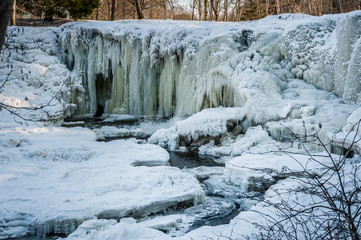Famous waterfall in Estonia. Keila-Joa Schloss Fall. Partly frozen waterfall by winter. Estonia. Winter landscape.