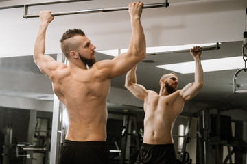 Fototapeta na wymiar Muscular man lift his body in the gym
