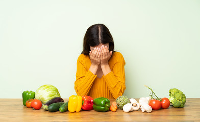 Fototapeta na wymiar Teenager girl with many vegetables with tired and sick expression