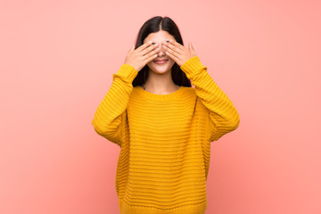 Teenager girl  over isolated pink wall covering eyes by hands