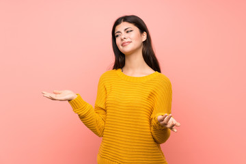 Teenager girl  over isolated pink wall unhappy for not understand something