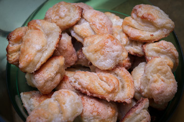 Ready-made cottage cheese biscuits sprinkled with sugar is in a plastic bowl