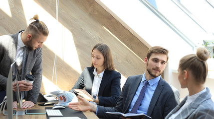 Business partners discussing documents and ideas at meeting.