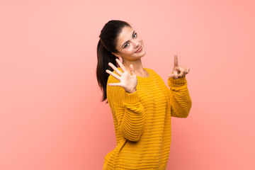 Teenager girl  over isolated pink wall counting seven with fingers