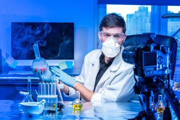 Distance education. Lecturer in respirator conducting chemical experiments online. Online webinars...