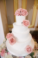 Big white wedding cake with fruit is on the table