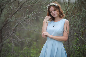 Girl in blue dress in green park