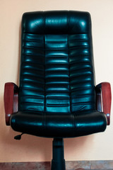 Leather armchair with wooden handrails. Leather chair in the office