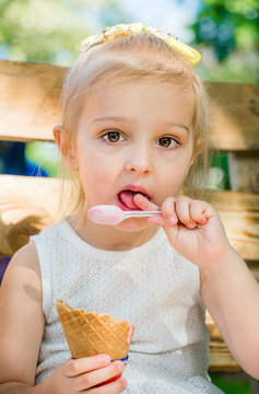 Funny little girl eats strawberry ice cream