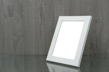 white wooden picture frame on the glass table, side view, mock-up