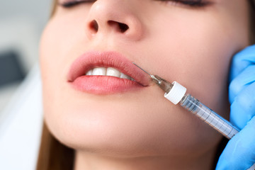 Lip Augmentation and Contouring. Closeup Of Beautician Doctor Hands Doing Beauty Procedure To...