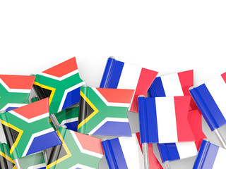Pins with flags of South Africa and france isolated on white.