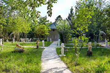 White alley in the park, ceramic species of animals on the green lawn